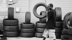 A man works across the street at a tire repair shop. 